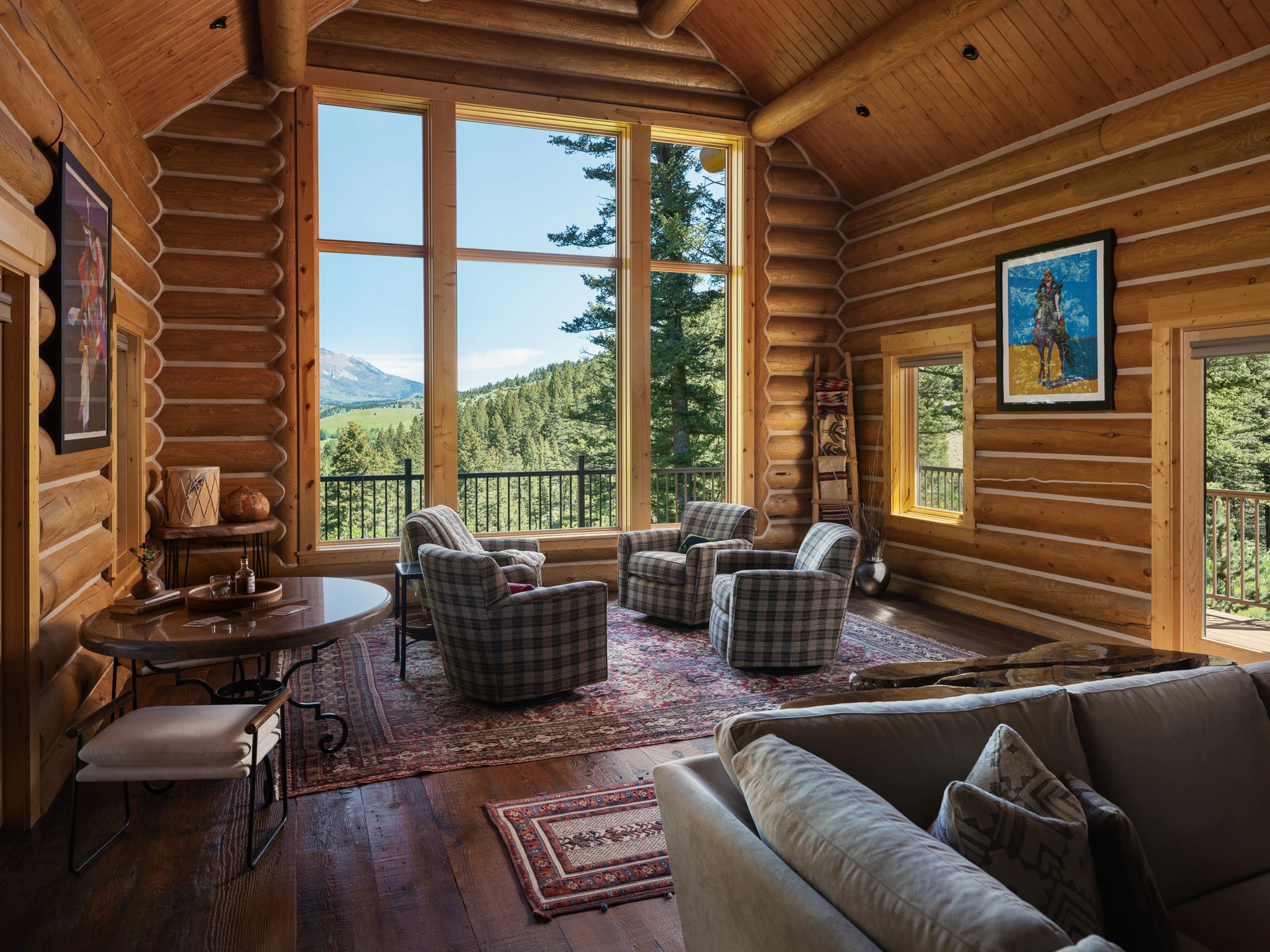 Great room beneath a vaulted log ceiling with plaid armchairs and mountain views — architectural photography Livingston Montana, Sam Schlauch Designs